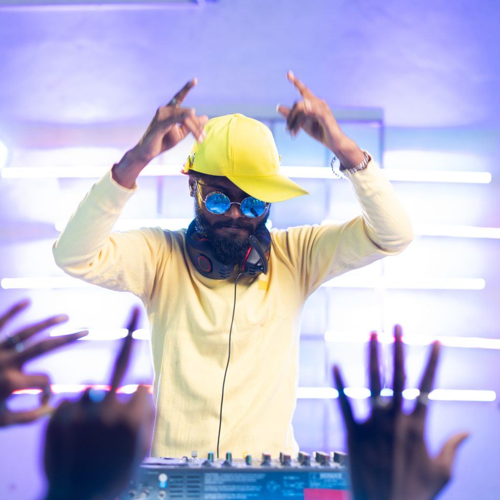 audience waving hand for dj player music at music concert - concept of nightclub, entertainment and hip hop rapper.